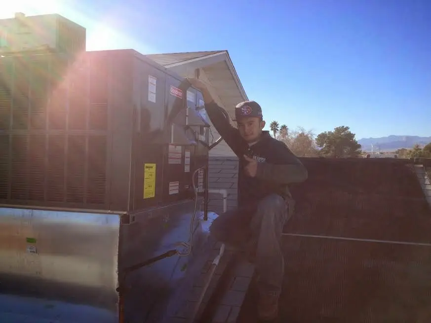 HVAC technician performing AC Tune-Up on a rooftop unit in Coos Bay